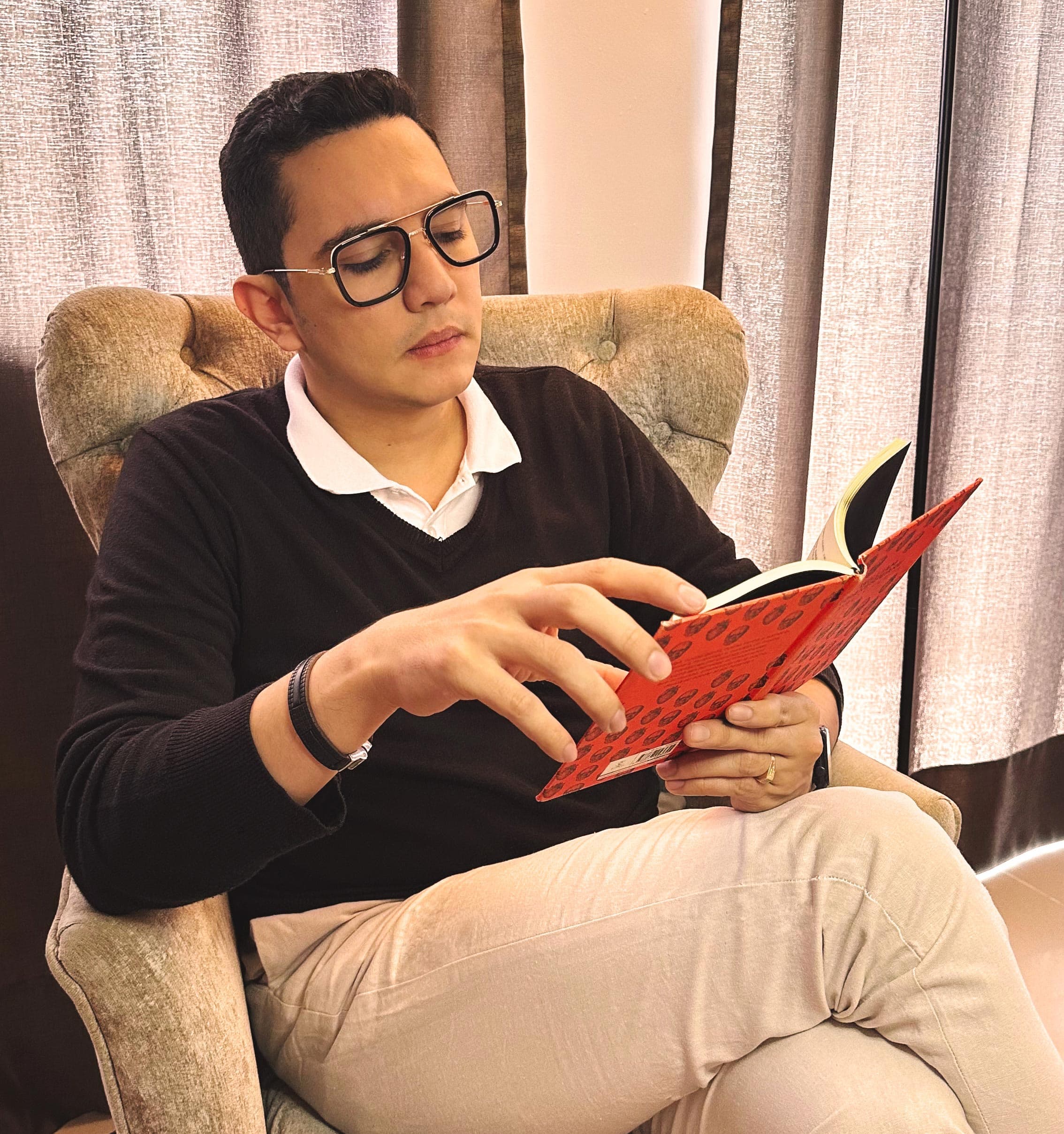 Dr William Guerrero foto leyendo libro en casa sentado