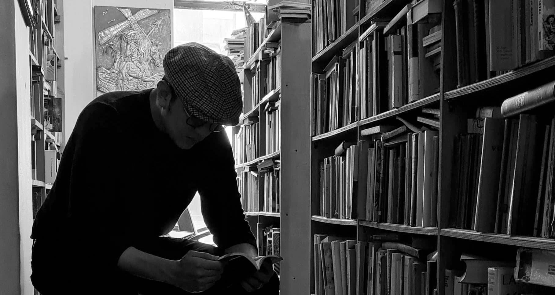 Dr William Guerrero foto leyendo libro en libreria sentado